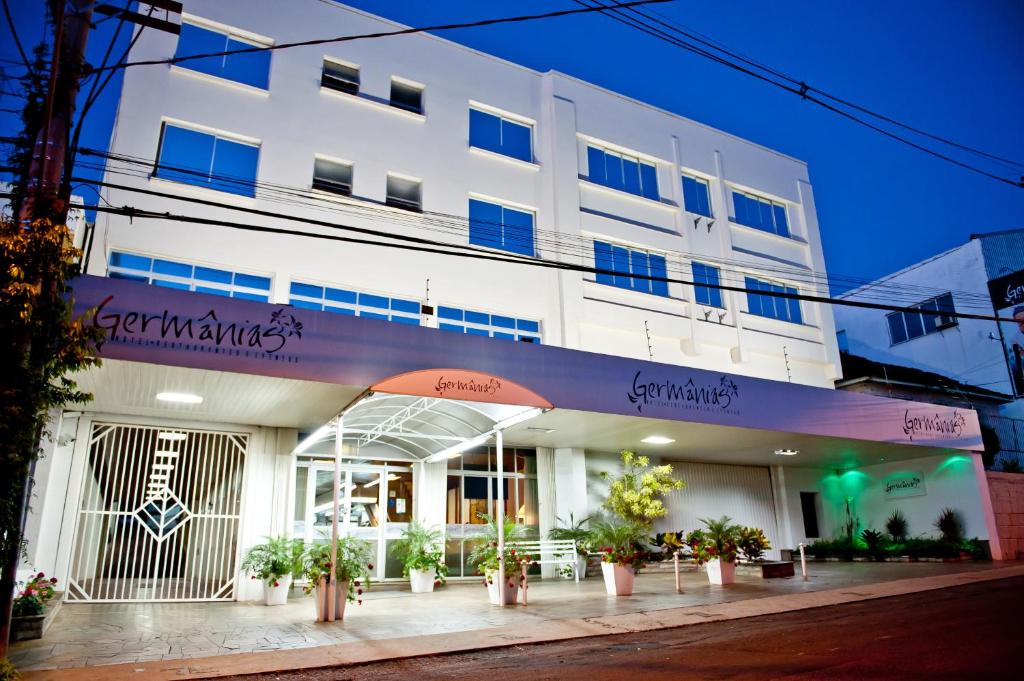 um edifício branco com plantas em frente em Germanias Blumen Hotel em Passo Fundo