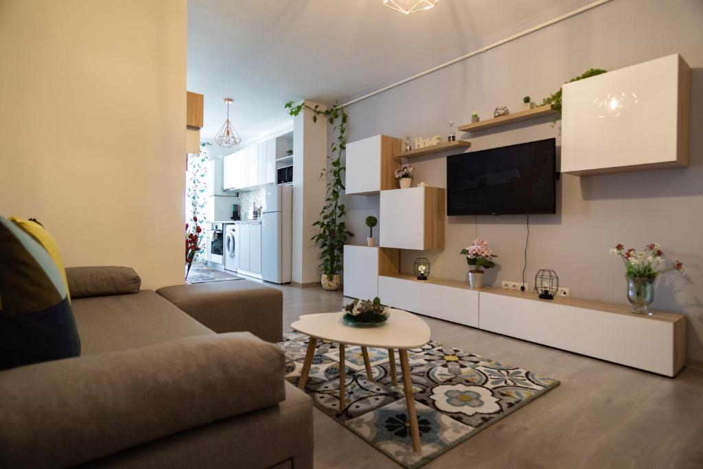 sala de estar con sofá y TV en Azure Home, en Cluj-Napoca