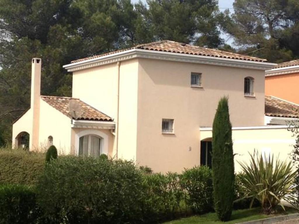 a white house with a chimney and bushes at Villa Royal Mougins Golf Club in Mougins