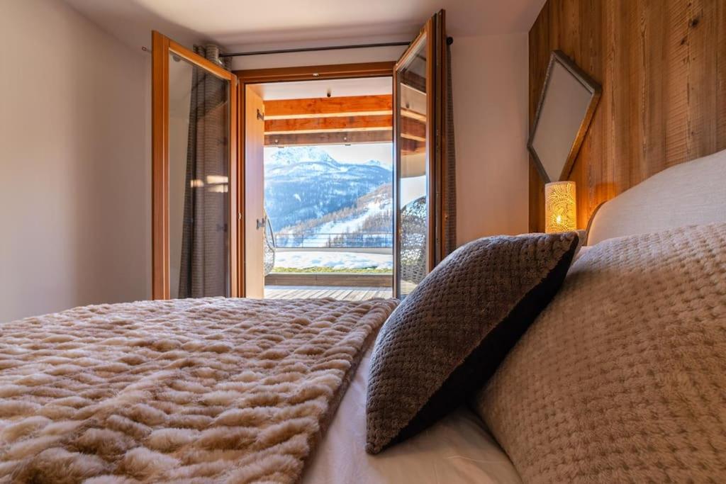 sypialnia z łóżkiem i widokiem na góry w obiekcie Appartement Abela 10 Pers Domaine de Serre Chevalier w mieście Saint-Chaffrey