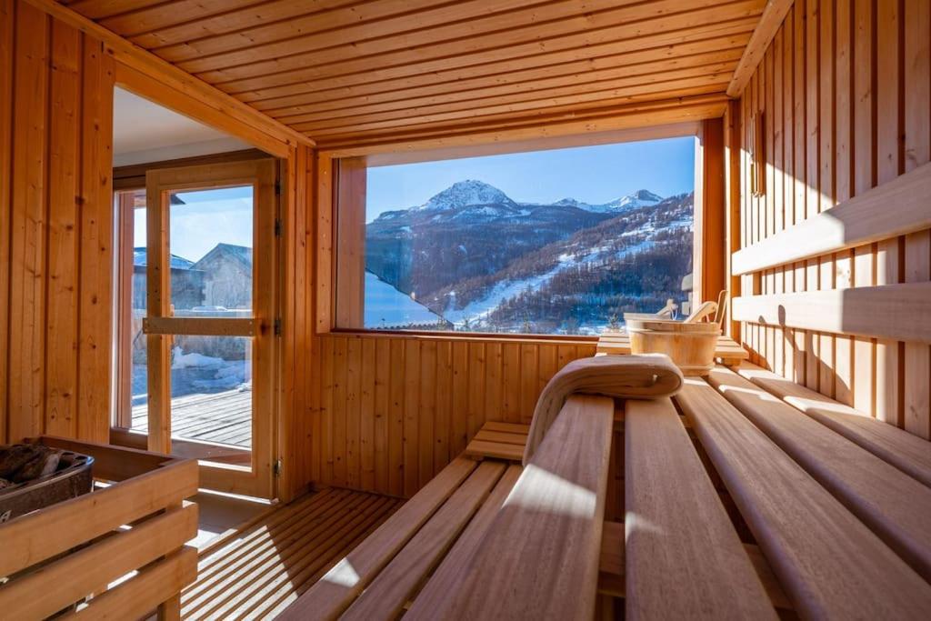 Pokój z dużym oknem w drewnianym domku w obiekcie Appartement Abela 10 Pers Domaine de Serre Chevalier w mieście Saint-Chaffrey