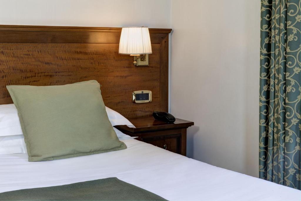 a bedroom with a bed with a pillow and a lamp at Grand Hotel Gianicolo in Rome