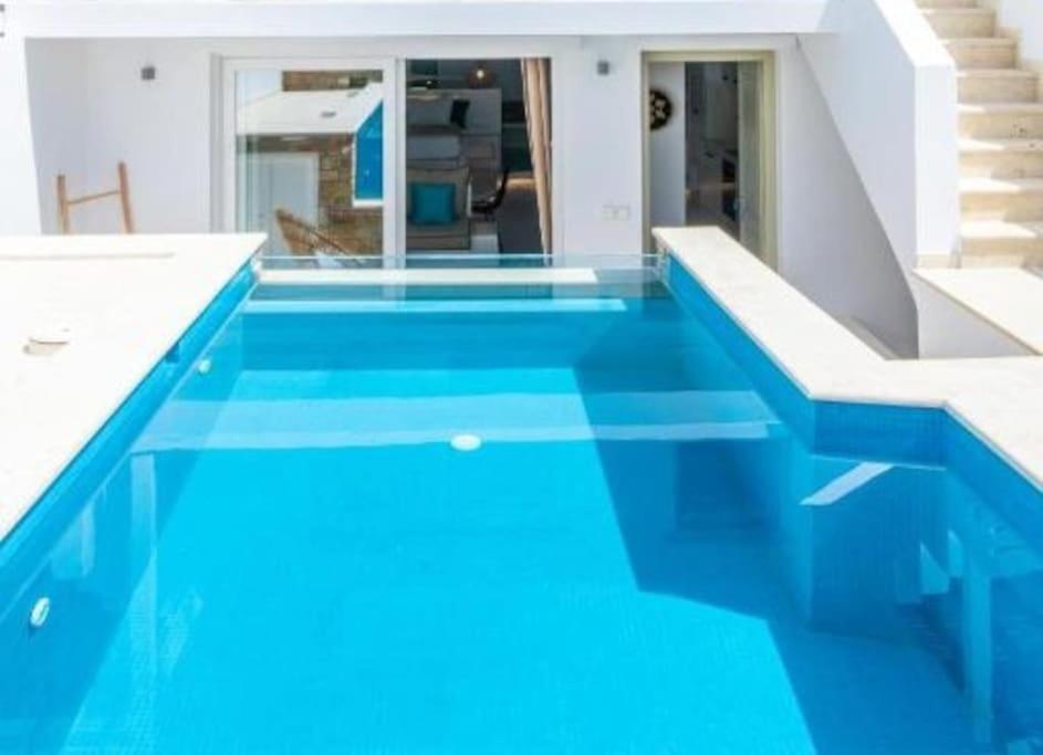 a swimming pool with blue water in a house at Dream House "B" in Tinos Town