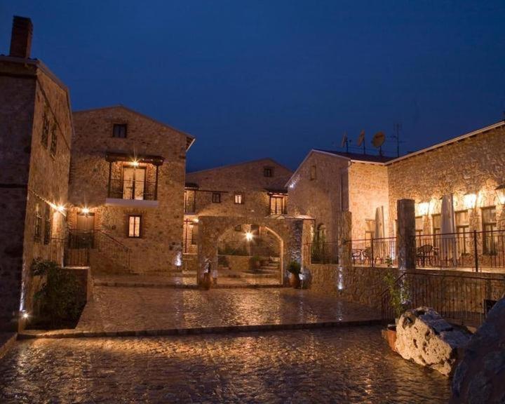 un edificio de piedra con una calle adoquinada por la noche en Lithea mountain resort and spa, en Florina