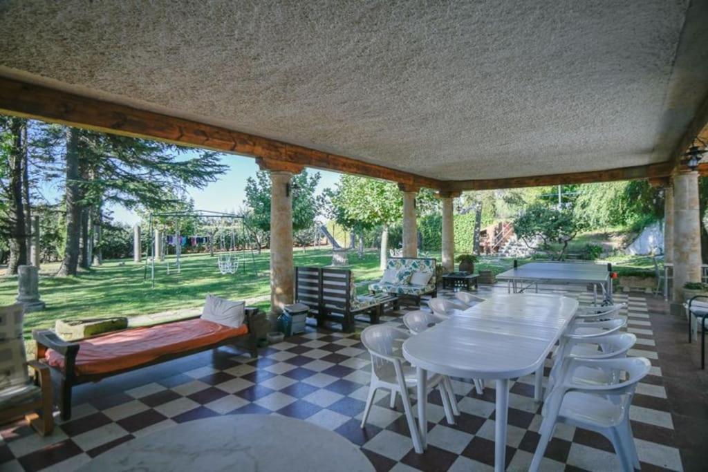 um pátio com mesas e cadeiras num piso xadrez em El Chalet de Gloria em Santa Marta de Tormes