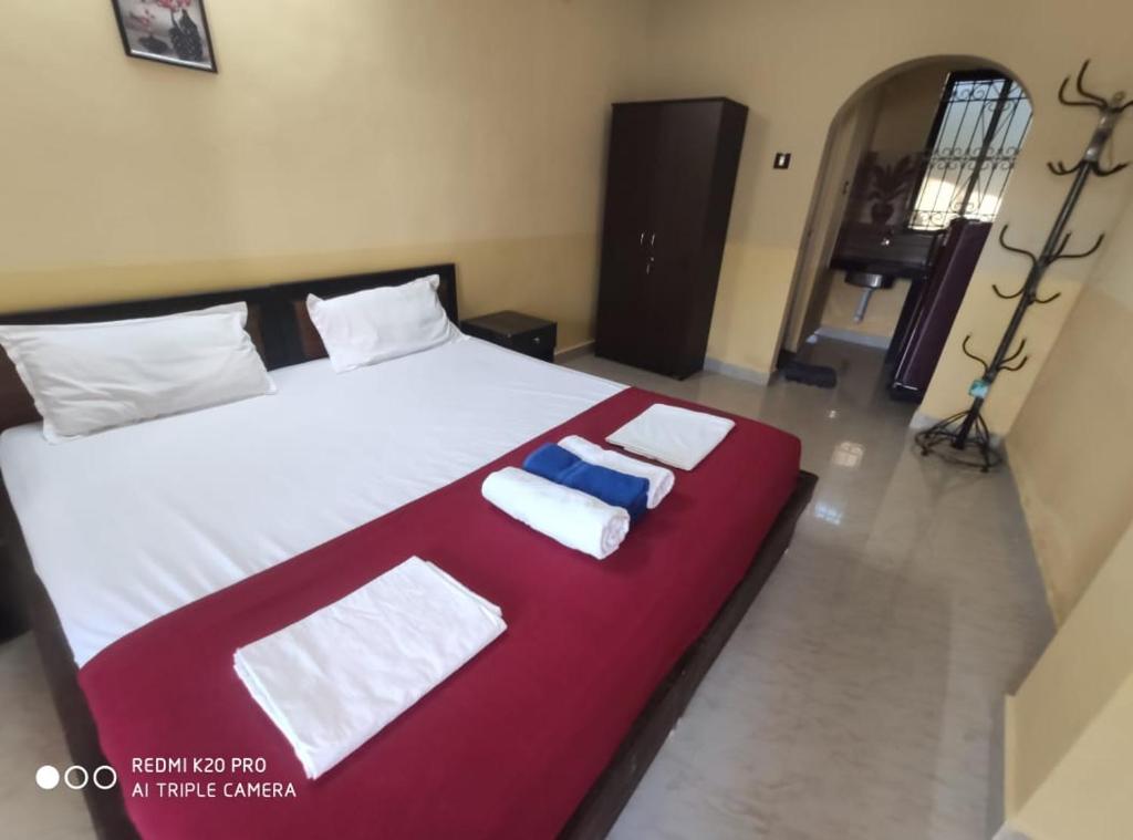a bedroom with a large bed with two towels on it at Regina Residency Inn in Palolem