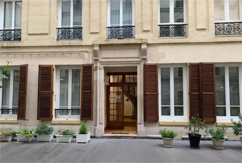 a building with wooden shuttered windows and a door at Appartement Paris près de Gare de Lyon in Paris