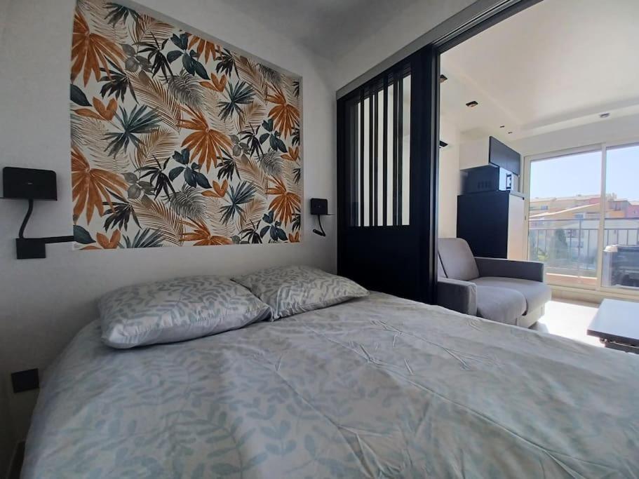 - une chambre avec un lit et une grande fenêtre dans l'établissement CAP'NOMAD Studio Côté Mer - balcon - piscine - parking, au Cap d'Agde