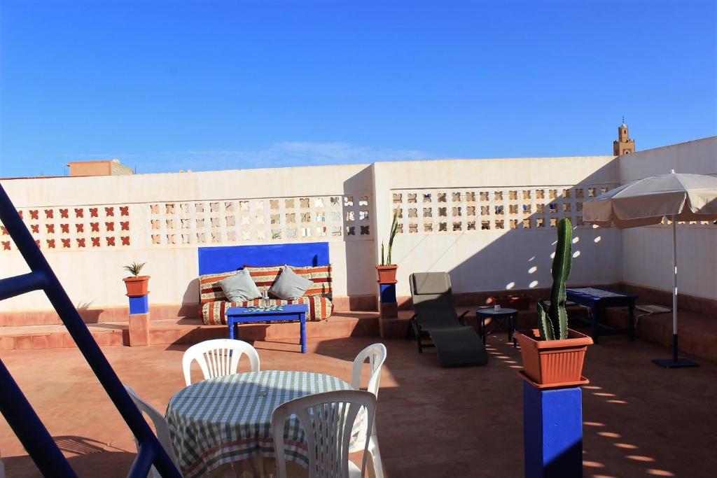 a patio with tables and chairs on a building at Asunfou : Appartement d'apaisement in Mirleft
