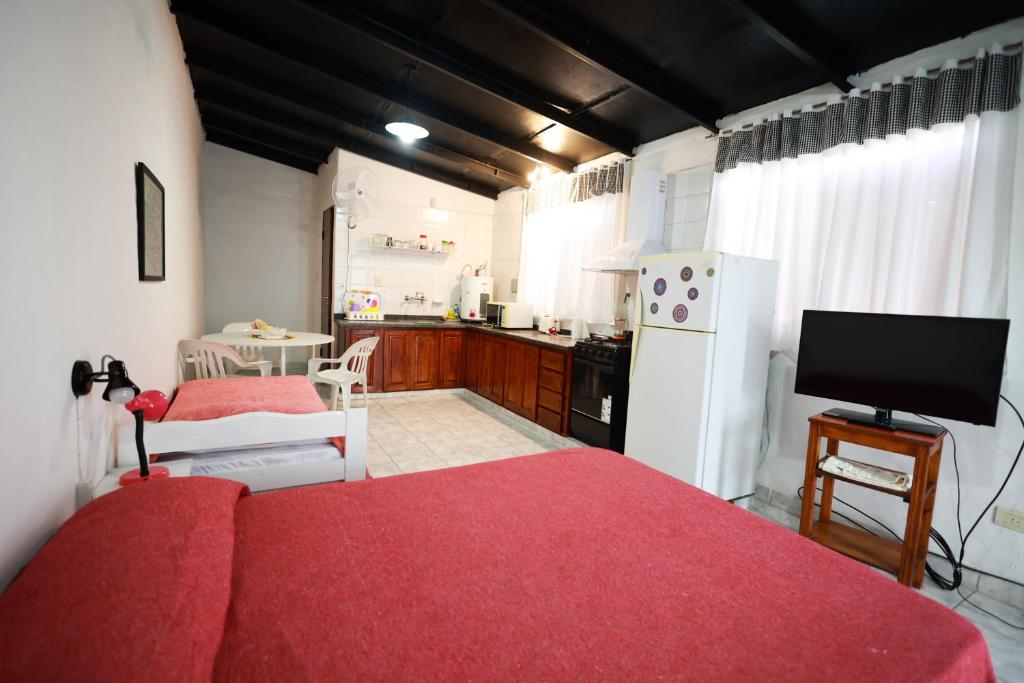 1 dormitorio con cama roja y cocina en Monoambiente familiar en San Rafael para 4 personas en barrio céntrico en San Rafael