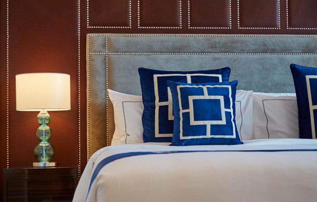 een slaapkamer met een bed met blauwe en witte kussens bij THE FACE Style in Kuala Lumpur