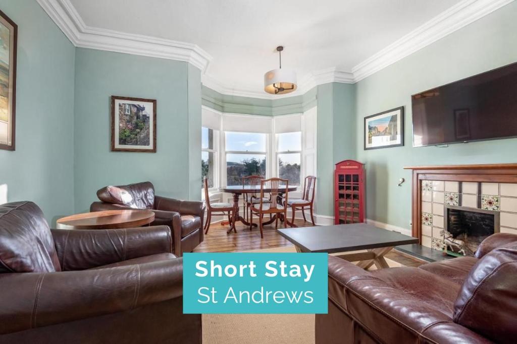 een woonkamer met lederen meubels en een eetkamer bij Magnolia - Near The Old Course - Sleeps 4 in St Andrews