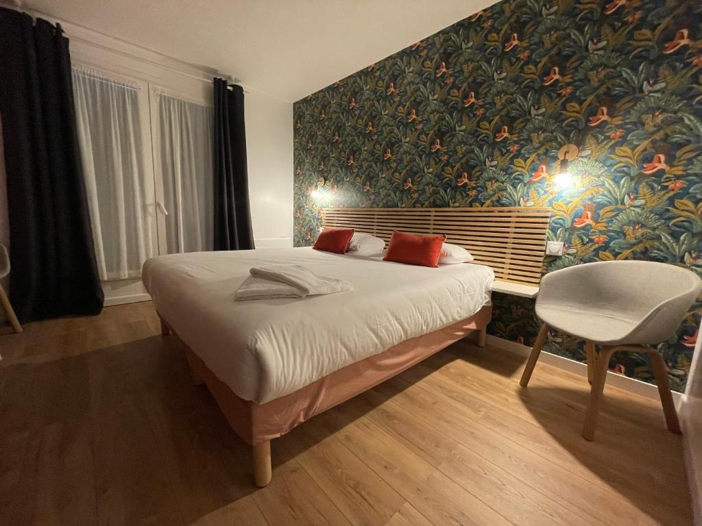 La GuérinièreにあるHôtel des Dunes Noirmoutierのベッドルーム1室(ベッド1台、テーブル、椅子付)