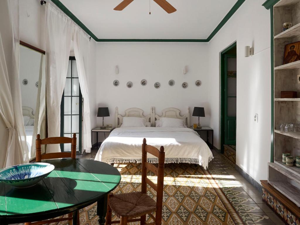 a bedroom with a bed and a table and chairs at Mesón La Hospedería in Cómpeta