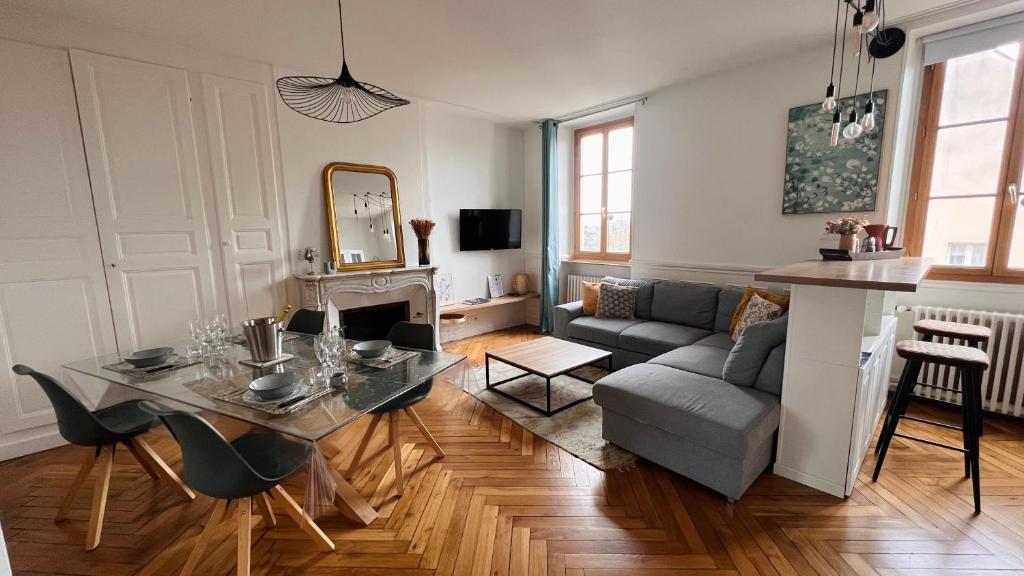 sala de estar con mesa y sofá en Charmant appartement plein centre ville - parking privé, en Auxerre