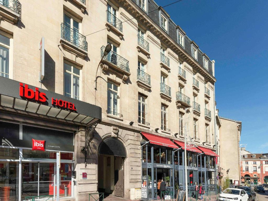 un gran edificio en una calle de la ciudad con tiendas en ibis Limoges Centre, en Limoges