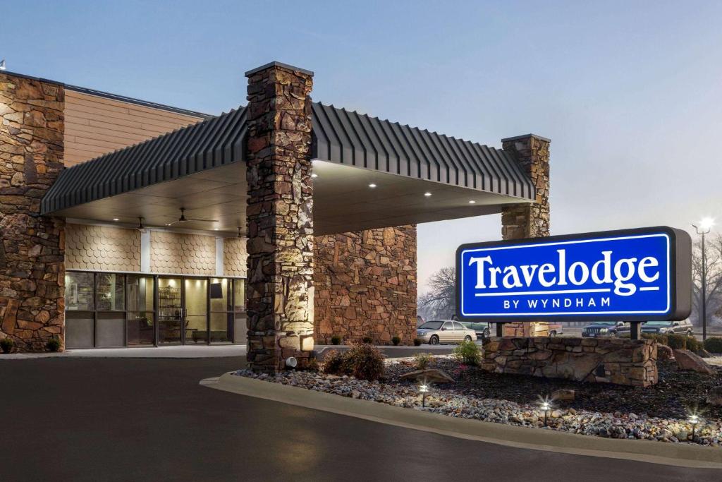 a sign in front of a building with a sign at Travelodge by Wyndham Coffeyville in Coffeyville