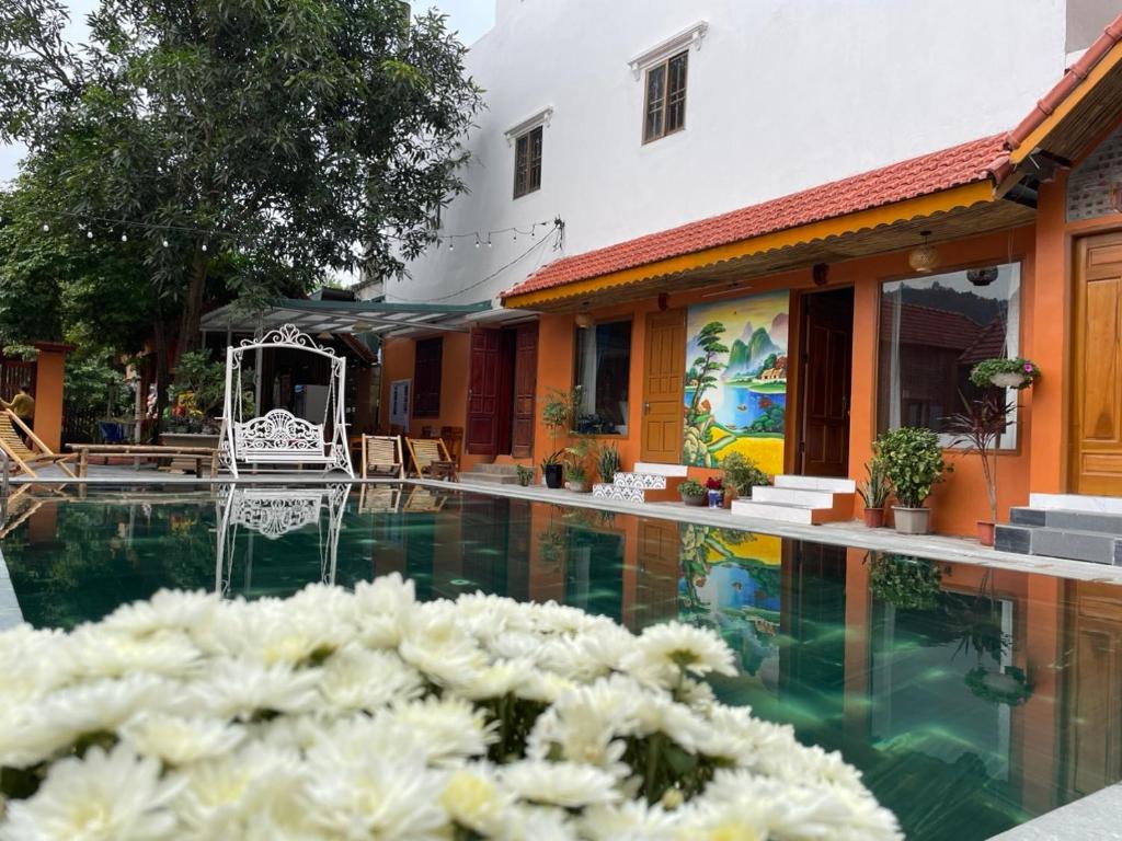 una piscina con fiori bianchi di fronte a un edificio di My Tam Coc Bungalow a Ninh Binh