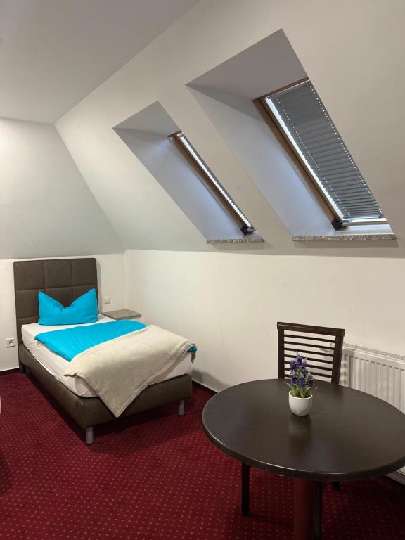 a bedroom with a bed and a table and skylights at Pension-Geli in Monplaisir