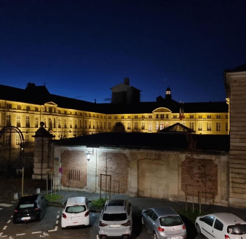 duży budynek z samochodami zaparkowanymi na parkingu w obiekcie Agathe w Rouen