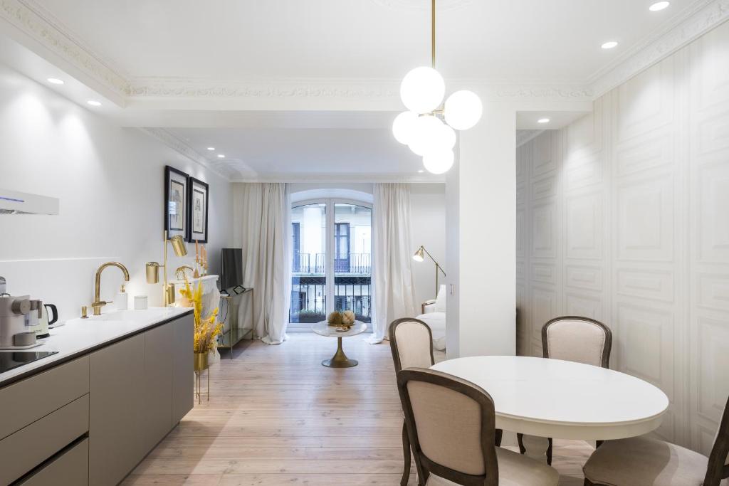 a white kitchen with a white table and chairs at Brand New I Beachfront I 3 min Old Town ANVERS in San Sebastián