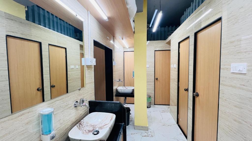 W łazience znajduje się umywalka, toaleta i lustro. w obiekcie Astropods w Bombaju