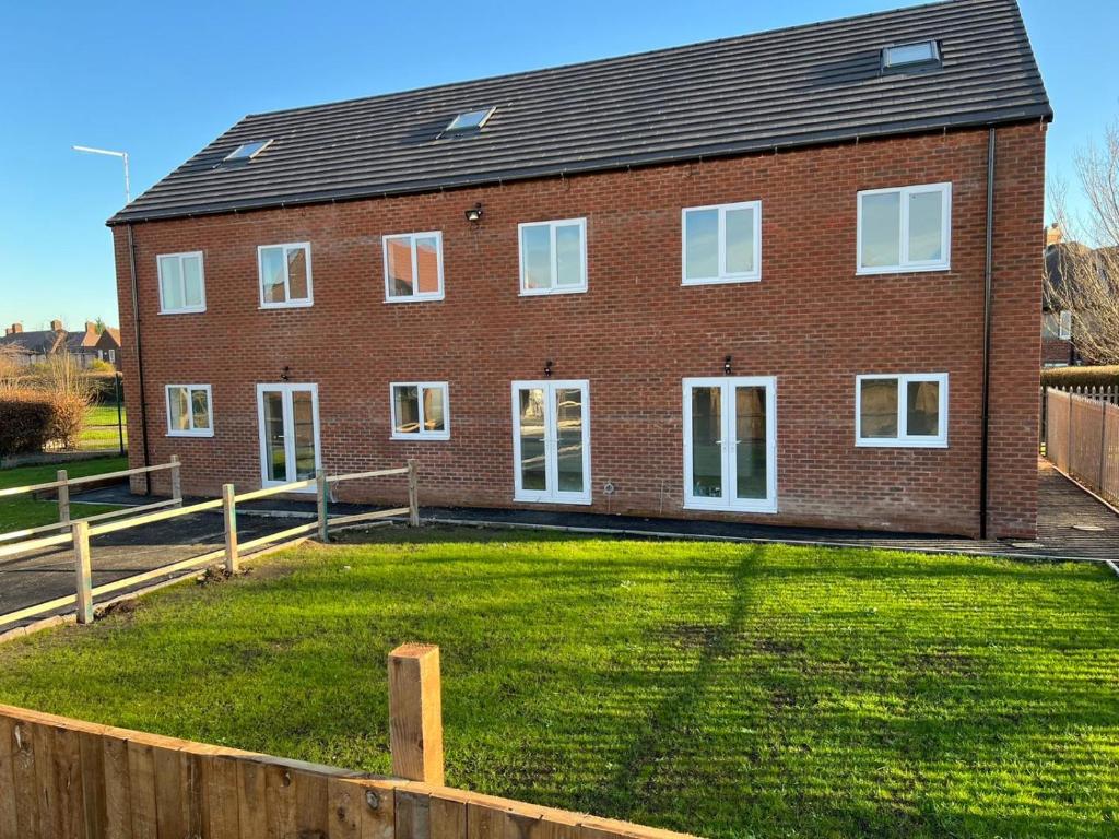 a brick house with a large yard in front of it at Campion Place Contractor Accommodation in Sheffield
