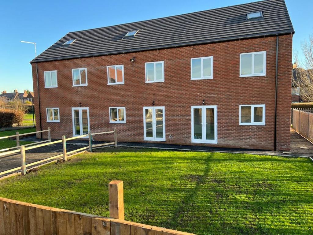 a brick house with a large yard in front of it at Campion Place in Sheffield