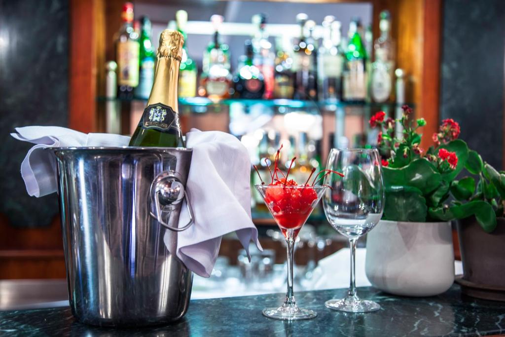 a bottle of champagne in a bucket next to two glasses at Grand Hotel Gianicolo in Rome