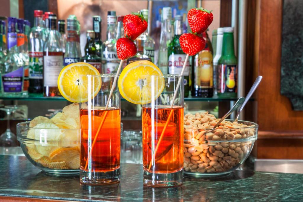 a bar with three cocktails with fruit and nuts at Grand Hotel Gianicolo in Rome