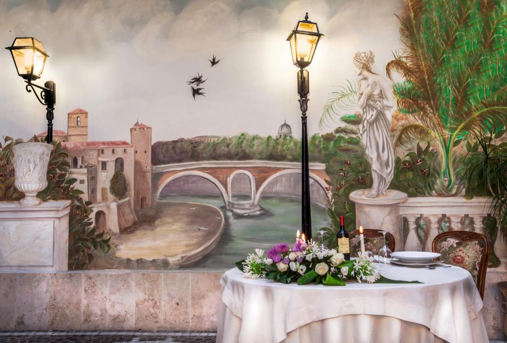 a table with flowers and a painting of a bridge at Grand Hotel Gianicolo in Rome