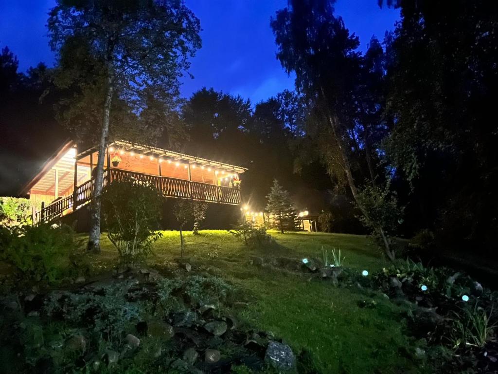Ein Haus, das nachts in einem Hof leuchtet in der Unterkunft ACTIVFARM DOMKI NA KASZUBACH Domek Dorotka in Gliśno