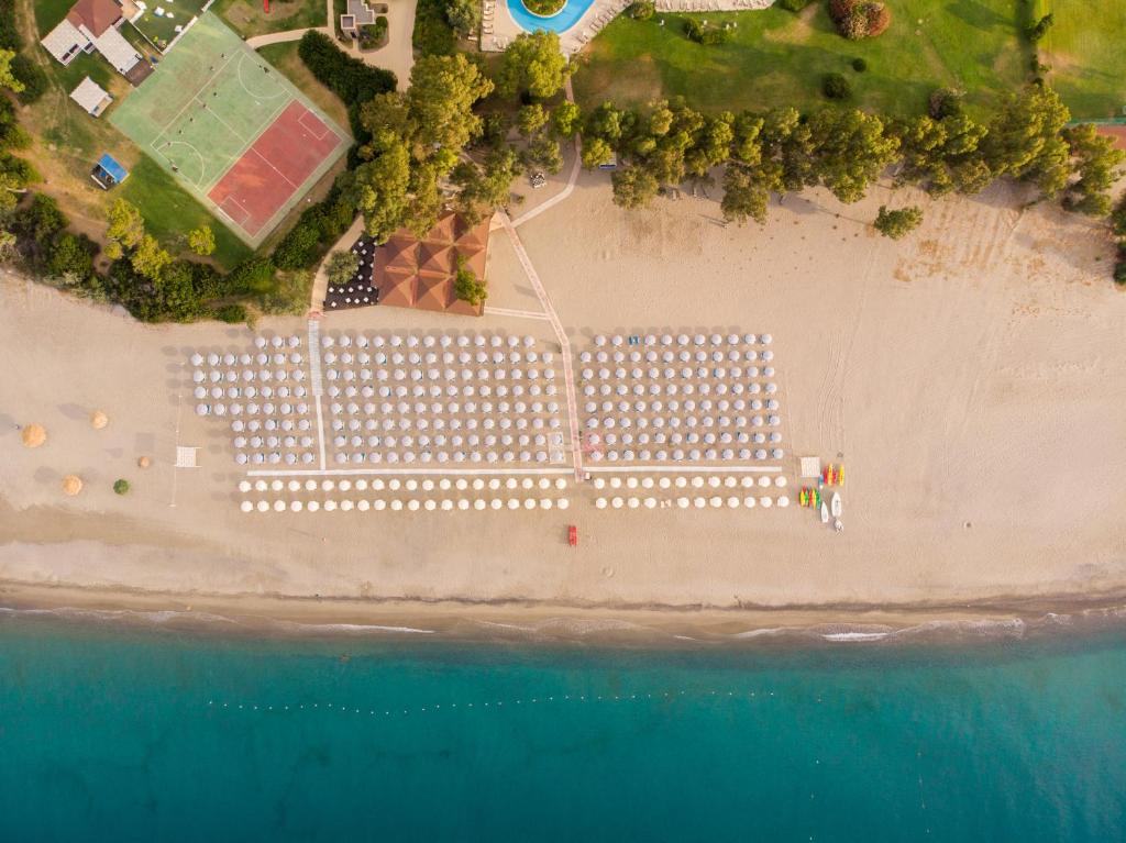 una vista aerea di una spiaggia con edifici bianchi di VOI Floriana Resort a Simeri Mare