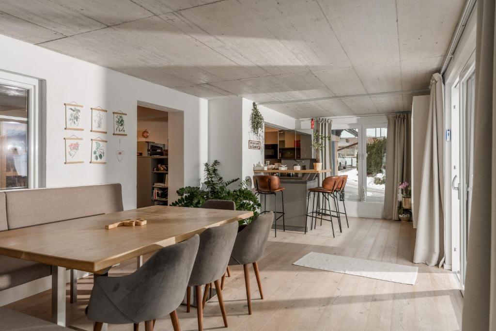 a dining room and living room with a wooden table and chairs at QUARTIER 179 in Schladming