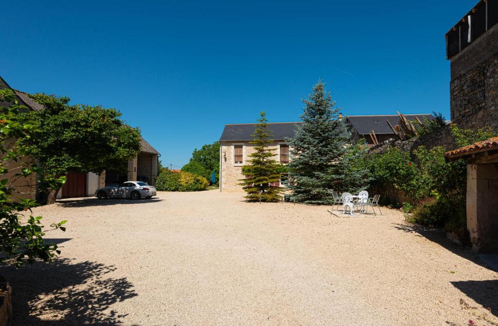 eine Auffahrt mit einem Haus und einem Auto auf einem Hof in der Unterkunft Chambre d'hôtes Saumur-Champigny 2 personnes in Montreuil-Bellay