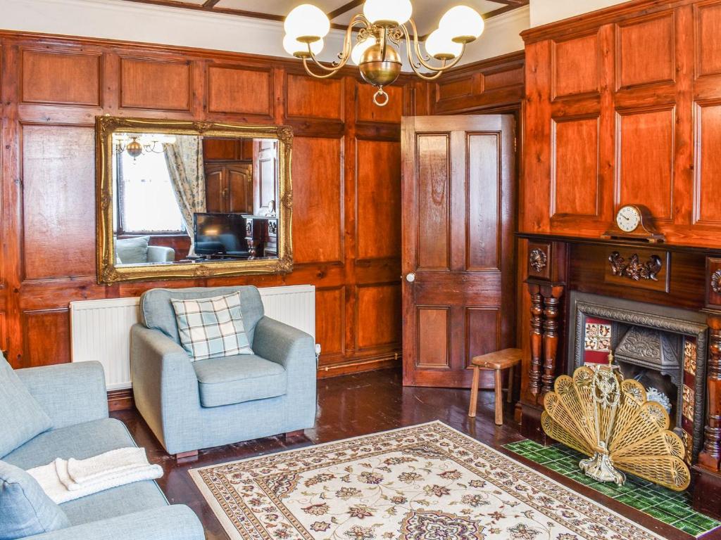 a living room with wooden walls and a fireplace at Heritage Lodge in Rhyl