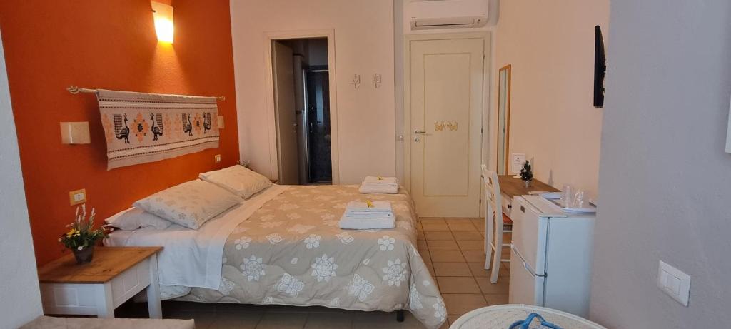 Schlafzimmer mit einem Bett, einem Tisch und einem Waschbecken in der Unterkunft B&B Il Piccolo Giardino in Villasimius