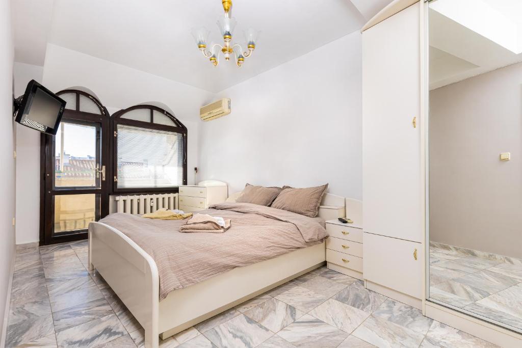 um quarto com uma cama e um espelho em Spacious 2-Bedroom Maisonette in City Centre em Plovdiv