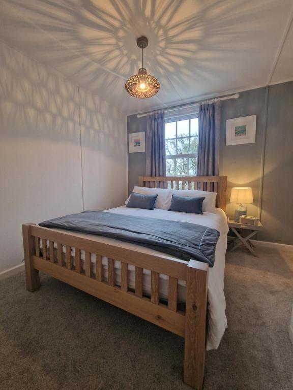 a bedroom with a large bed with a blue comforter at Small Cottage close to Carbis Bay Beach & St Ives in Carbis Bay