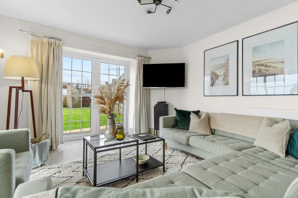 a living room with a couch and a table at NEW 2023 Modern Luxury Holiday Home on the Beach in Devon - Free Parking, Pets Welcome, Sleeps 10 in Plymouth