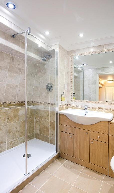 a bathroom with a shower and a sink at Old Hunstanton Le Strange Arms Hotel in Hunstanton