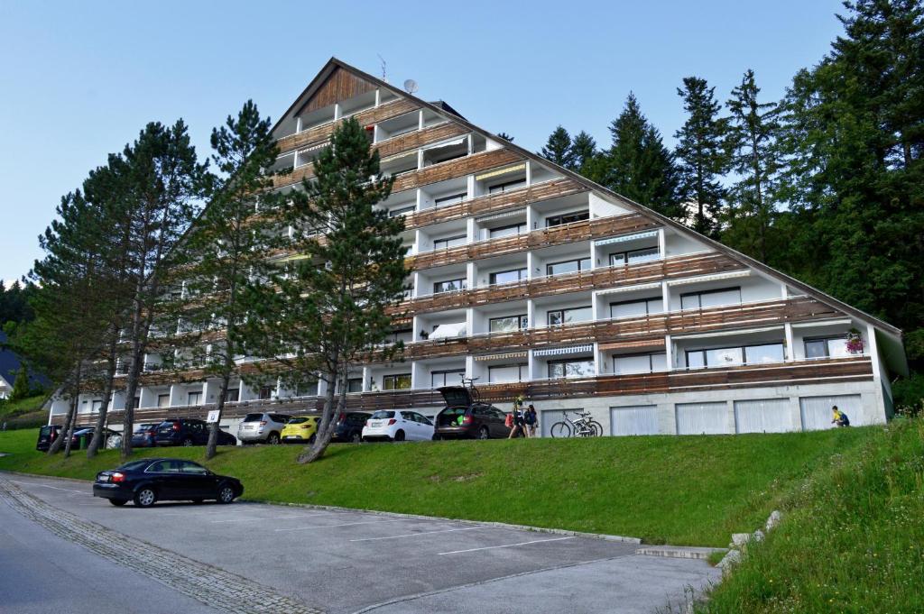 a large building with a car parked in front of it at Sonnenalm apartments in Bad Mitterndorf