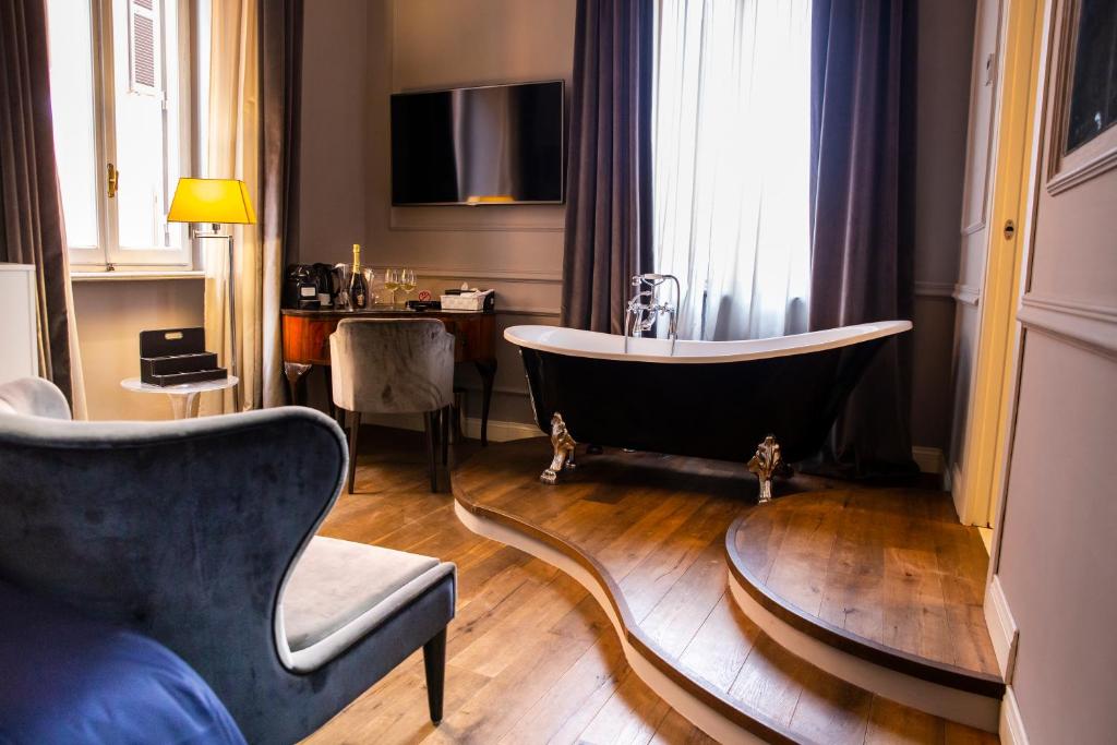 a room with a bath tub and a chair at Relais San Lorenzo In Lucina in Rome