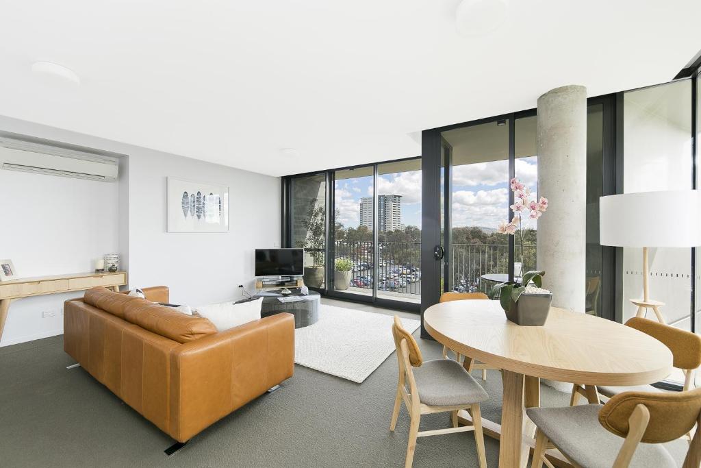 a living room with a couch and a table at CityStyle Apartments - BELCONNEN in Canberra