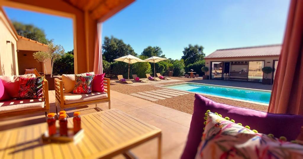 uitzicht op een zwembad met stoelen en een tafel bij **** VILLA CASA DI FIUMU **** in Porto-Vecchio
