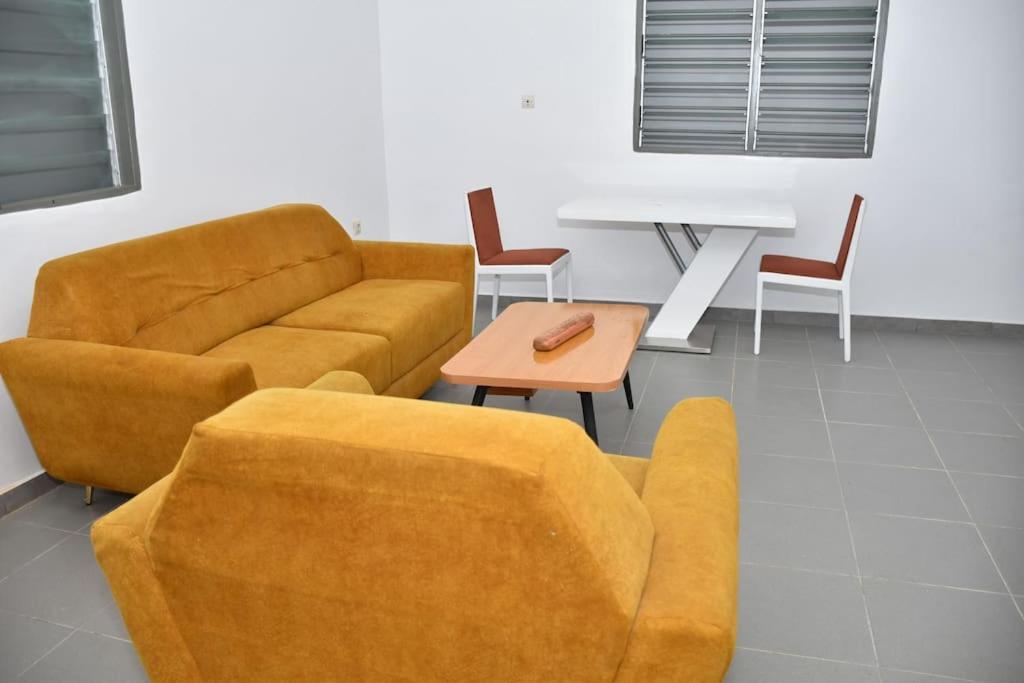 a living room with a couch and a table and chairs at Tranquillité Cotonou in Cotonou