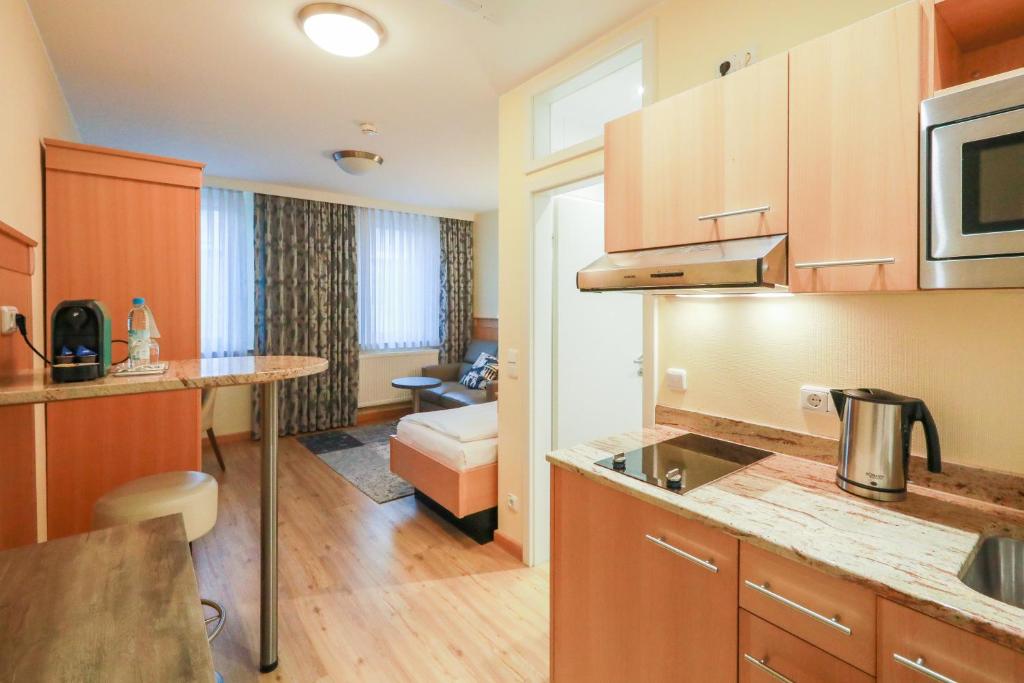eine Küche und ein Wohnzimmer mit einem Sofa in der Unterkunft Gästehaus Kral in Erlangen