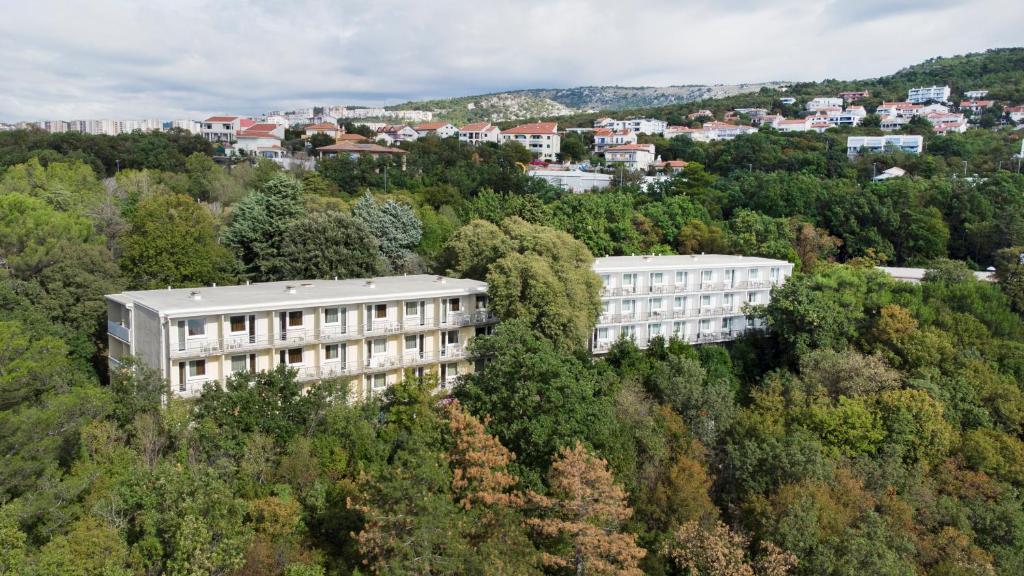 um edifício de apartamentos no meio das árvores em Boarding House Lucija em Kostrena