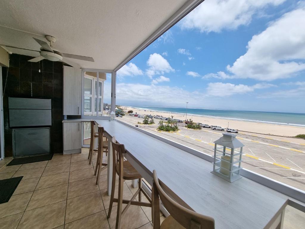 a bar with chairs and a view of the beach at Diaz Views 10 in Jeffreys Bay