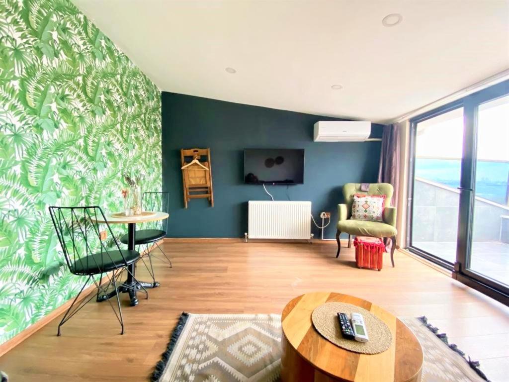 a living room with green walls and a table and chairs at Jazzy Homes - Modern & Stylish Flat - Bosphorus View, Terrace in Istanbul